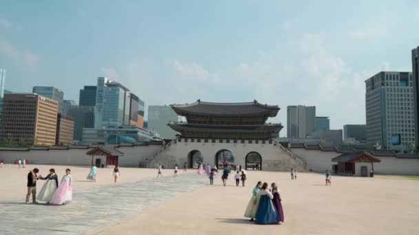 韓国の景福宮光化門とソウルの街並みを一望できます 手前に伝統的な韓服を着た女性観光客 — ストック動画