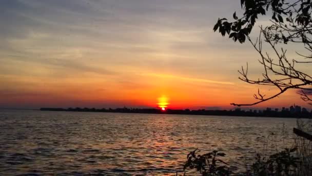 湿気の多い夜にオンタリオ湖の上に沈む美しい空と夏の太陽の静的なワイドショット — ストック動画