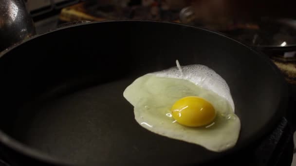 Trago Medio Dos Huevos Fritos Una Sartén — Vídeo de stock