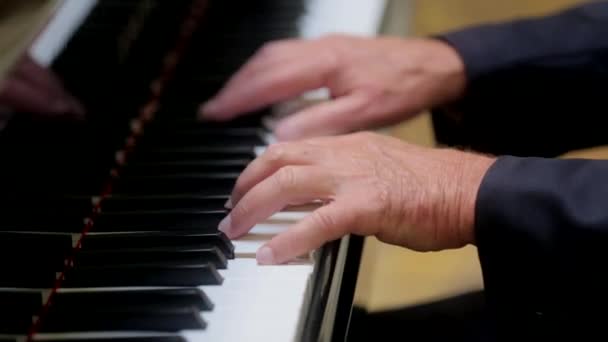 男人弹着婴儿般宏伟的钢琴把注意力集中在手放音乐上 — 图库视频影像