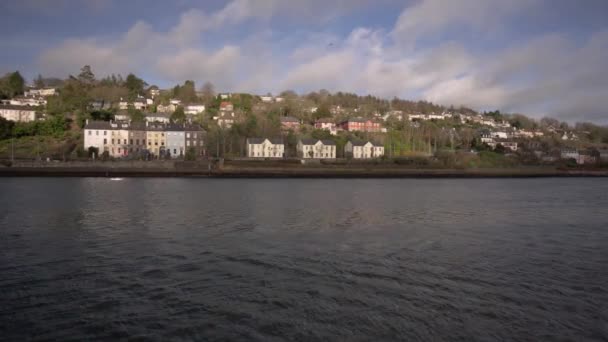 在爱尔兰的一个阳光明媚的日子里 在一个有房子的城市里 在背景中 汽车经过 泛舟拍下了河流和风景 — 图库视频影像