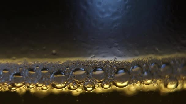 啤酒上方泡沫的巨幅特写 杯子上有缓慢运动的活跃的气泡气体 二氧化碳 黑色背景 最佳商业广告 广告推广 — 图库视频影像