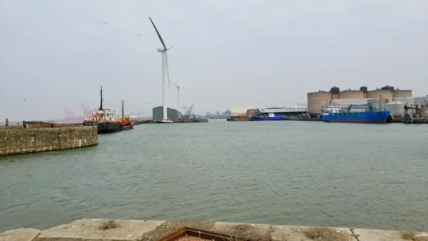 配备风力发电机组和停泊在港口的旧船的码头区 — 图库视频影像