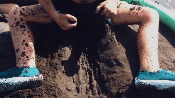 Seaside Boy Cavando Agujero Arena Oscura Playa Compuesta Minerales Volcánicos — Vídeos de Stock