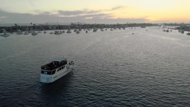 游艇俯瞰着头顶 在夕阳西下的金光闪闪的码头航行 加利福尼亚奥兰治县纽波特海滩的纽波特湾闭幕式 — 图库视频影像