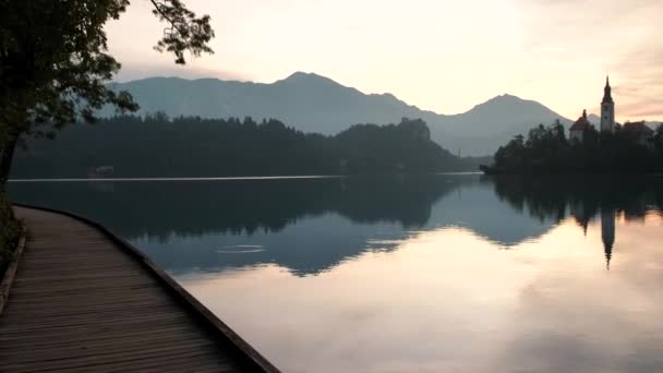 日の出時の湖の美しい反射 湖で美しい朝は城と背景にアルプスで満たされた — ストック動画