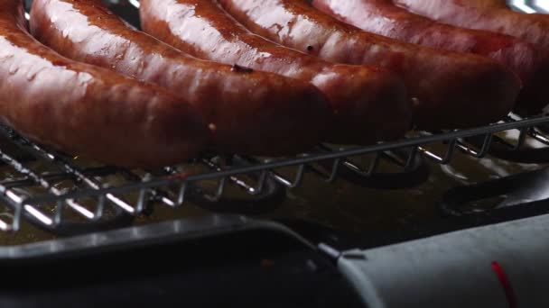 热腾腾的新鲜德国腊肠在电烤炉烤巴伐利亚传统猪肠外壳绿色烹调对抗全球变暖的特写镜头 — 图库视频影像