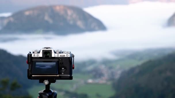 Fujifilm相机在斯洛文尼亚景观中的三脚架上拍照 一个男人站在那里拍摄旅游景点的照片 — 图库视频影像