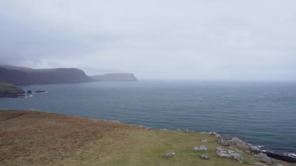 Panning Shot Van Neist Point Vuurtoren Met Rotsachtige Kliffen Voorgrond — Stockvideo