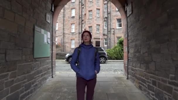 在爱丁堡老城区迪安村 多莉拍到一个女孩穿过一条建筑通道的照片 — 图库视频影像
