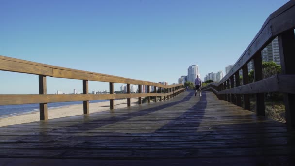 老人走在海滩边的木板路上 乌拉圭 埃斯特角 — 图库视频影像