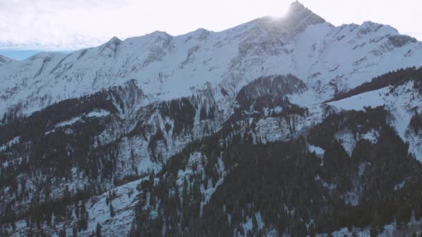 空中无人驾驶飞机向右飞去 当太阳照在镜片上的时候 可以看到雪山高耸的白天 — 图库视频影像