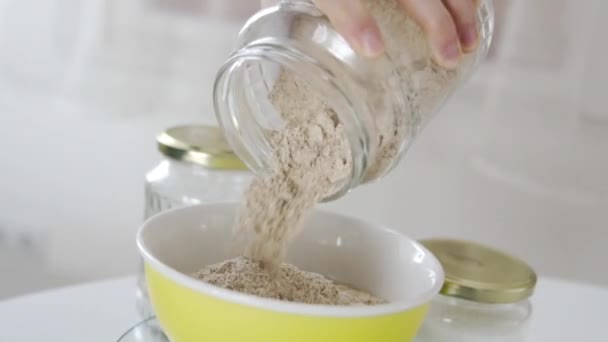 台所のガラス瓶からアーモンド小麦を弓に入れます — ストック動画