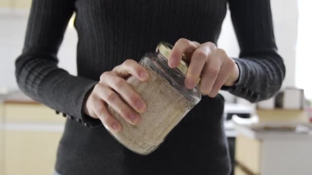 Медленный Выстрел Женщина Кухне Открывая Банку Полную Коричневой Миндальной Пшеницы — стоковое видео