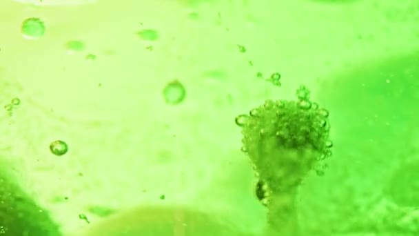 大小不等的绿色气泡在明亮的绿色水中漂浮和滴落的宏观镜头 — 图库视频影像