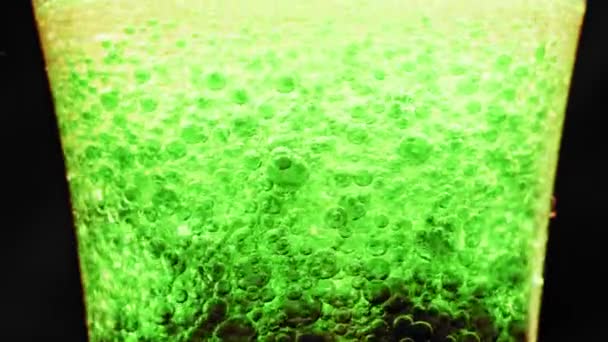 Μακροεντολή Πλάνο Αφρώδεις Πράσινες Φυσαλίδες Επιπλέουν Γύρω Ένα Ποτήρι Φωτεινό — Αρχείο Βίντεο