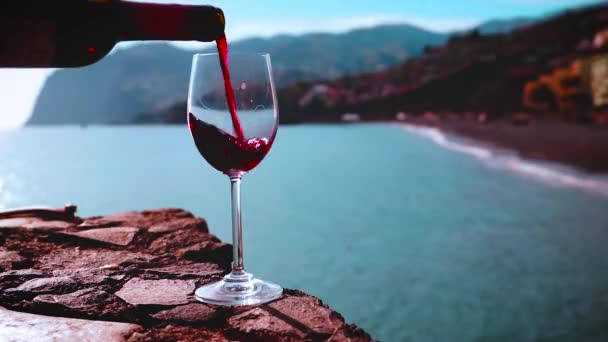 Rode Wijn Gegoten Wijnglas Met Uitzicht Het Strand Met Bergen — Stockvideo