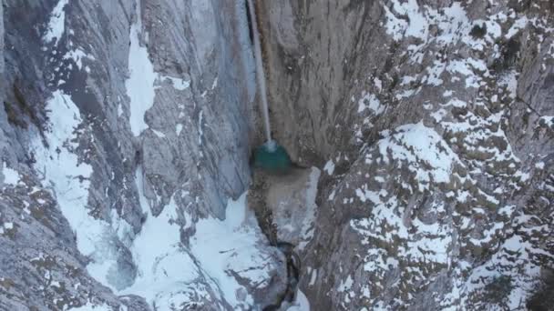 冬に雪に覆われた岩壁で滝を見下ろして飛ぶドロン スロベニアのクランジスカ ゴラにあるマルトゥジェクの滝の空中 Trial National Park — ストック動画