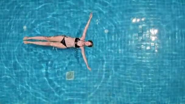 Mavi Havuzda Rahatça Yüzen Sarışın Kadının Yukarıdan Aşağı Görüntüsü — Stok video