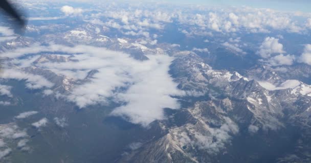 頭上の飛行機の座席からロッキー山脈の景色 少し曇った空と雪をかぶった山々を眺めプロペラ — ストック動画