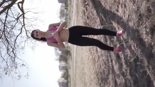 垂直回転スローモーションフルボディショットの若い女性ウォーミングアップ手と足前にワークアウト — ストック動画