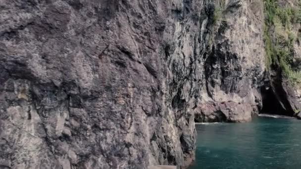 隐秘的隐蔽海滩 有天然火山石灰岩海洞 黑砂和晶莹碧绿的水 4K娃娃射击 — 图库视频影像