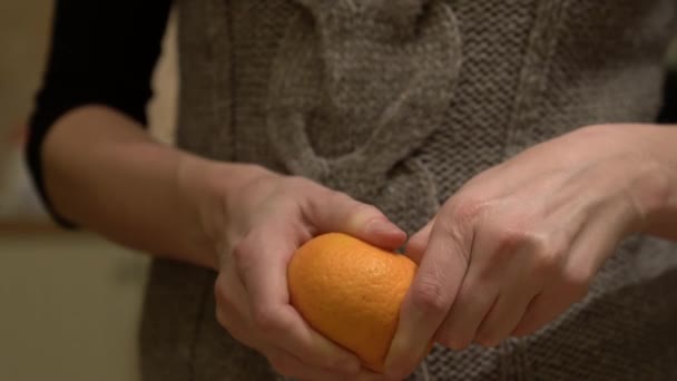 オレンジ色のみかんの手を閉じるショットを剥離女性 — ストック動画