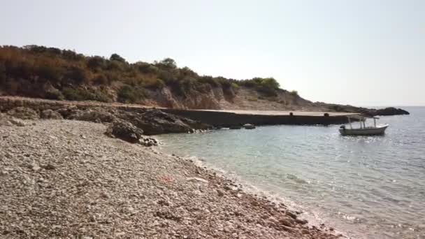 克罗地亚Vis岛上Barjoska海滩的混凝土码头和卵石沙滩的右面泛舟 孤舟在波浪中荡漾 — 图库视频影像