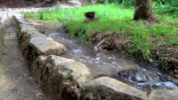 Agua Que Fluye Junto Muro Piedra Largo Una Pasarela Parque — Vídeos de Stock