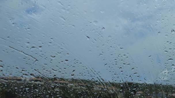 Close Gotas Chuva Caindo Pára Brisas Carro Janela Com Casas — Vídeo de Stock