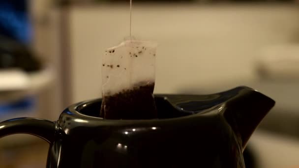 ティーバッグのクローズアップショットは ティーポットに何度も浸した お茶を作る — ストック動画