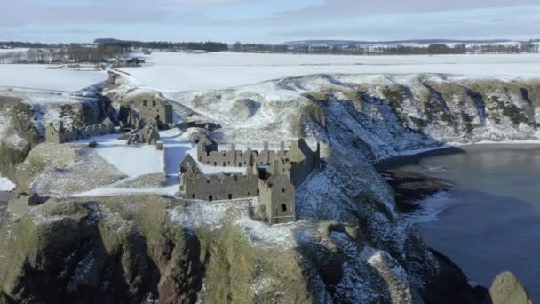 在一个阳光明媚的冬日 苏格兰阿伯丁郡的斯通黑文 从空中俯瞰邓诺塔尔城堡的废墟 周围都是雪 城堡东端的R L旋转视图 — 图库视频影像