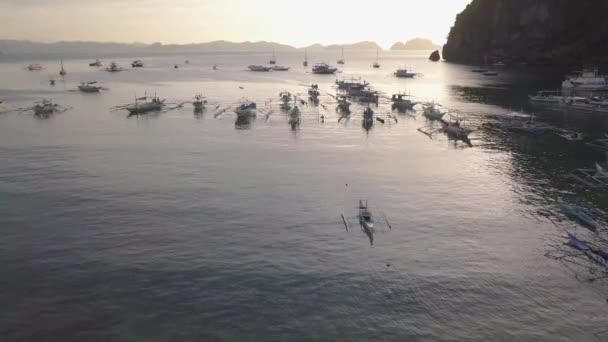 Airial Drone Shot Outriggerバンカ バンカ ボート フィリピン パラワン州エルニドのコロンコン ビーチで日没時に湾に停泊 — ストック動画