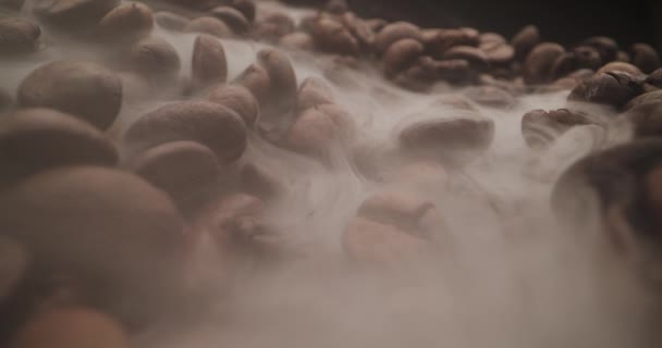 コーヒー豆の上で煙を焙煎するユニークなマクロプローブショット ドリーイン — ストック動画