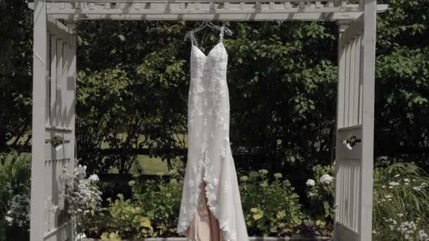 Gyönyörű Tervező Esküvői Ruha Fúj Szél Miközben Lóg Egy Pergola — Stock videók