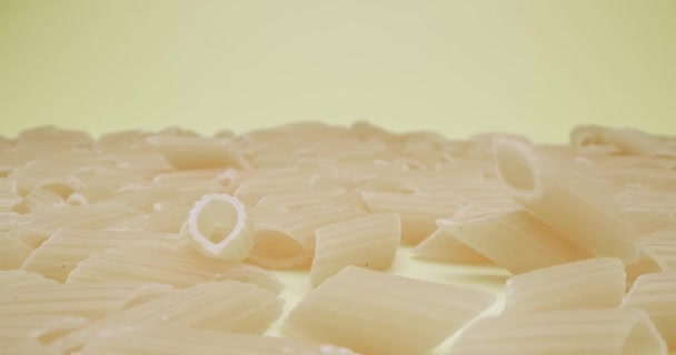 Echtzeit Nahaufnahme Von Fallenden Mezze Penne Rigate Pasta Auf Gelbem — Stockvideo