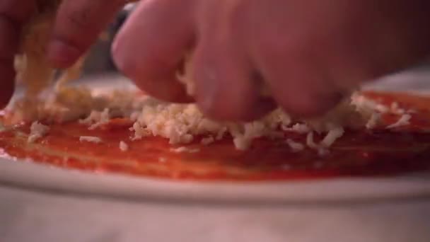 Mani Spruzzando Formaggio Triturato Sulla Pasta Pizza Con Salsa Pomodoro — Video Stock