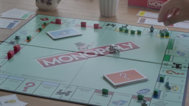 Menschen Beim Klassischen Brettspiel Monopoly Gefilmt Auf Einem Stativ — Stockvideo