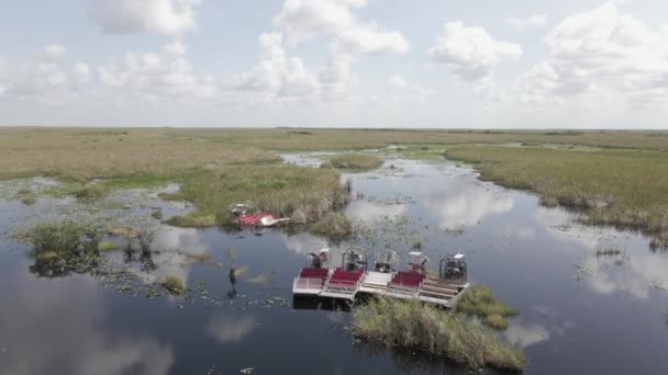 在黑暗的沼泽地边排成一排的生态旅游飞艇等待着游客 — 图库视频影像