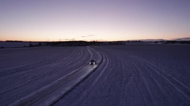 冬季雪景下冰雪覆盖路的空中景观驾驶车 — 图库视频影像