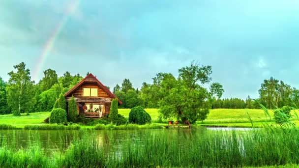 田園風景の中で自然湖や空の虹に木造住宅の時間経過ショット — ストック動画