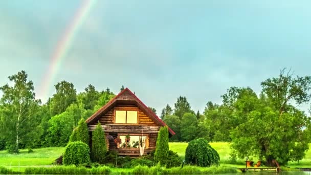 郁郁葱葱的森林中的美丽的木制小屋 天空中的彩虹 时间流逝 — 图库视频影像