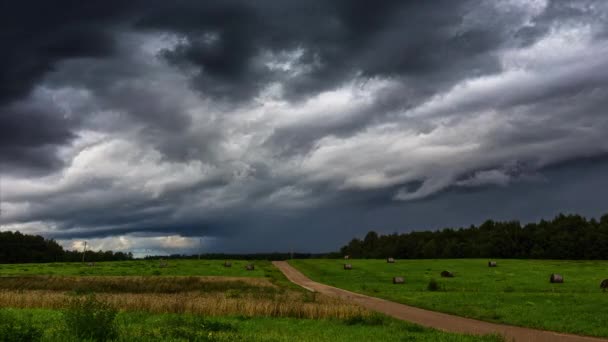Tiro Nuvens Escuras Místicas Voando Sobre Campo Verde Com Fardos — Vídeo de Stock