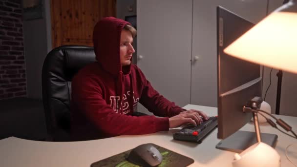 Bordo Kapüşonlu Genç Adam Bilgisayar Klavyesinin Başına Geçip Bilgisayar Sistemine — Stok video