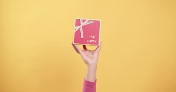 여성들은 손바닥에 상자를 흔들면서 노란색 아래로 내려간다 선물을 주거나 놀라게 — 비디오