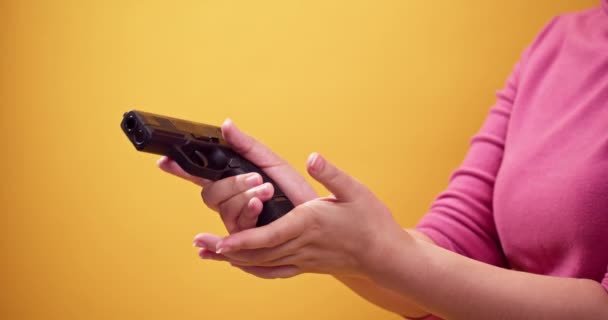 近身女人拿着一把手枪把枪口对准明亮的黄色背景 自卫概念 — 图库视频影像