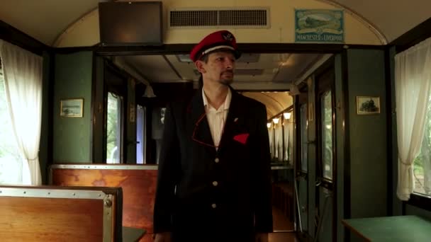 铁路售票员 戴着红帽子 在老式列车的空老式餐车中走来走去 同时检查 向后行走 跟随镜头 — 图库视频影像