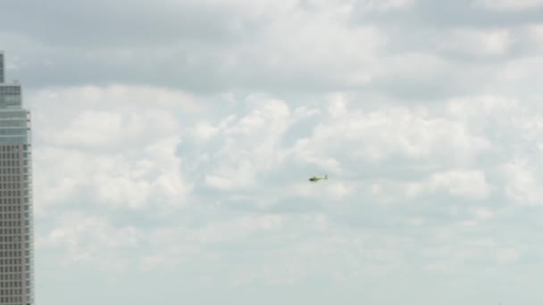 在多云的一天 一架黄色的医疗直升机在荷兰鹿特丹市上空盘旋 拍摄到了惊人的照片 — 图库视频影像