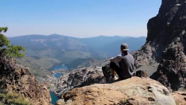 Mladý Muž Sedí Vrcholu Hory Dívá Malebné Jezero Pohoří Sierra — Stock video