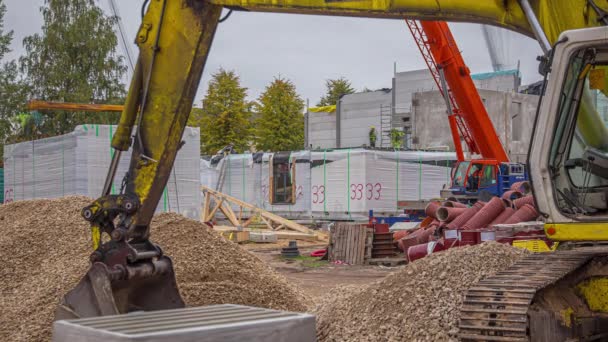 在挖掘机的扶手下或吊臂下看着在建筑工地工作的人 — 图库视频影像